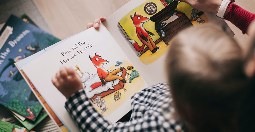 caretaker and child reading a book